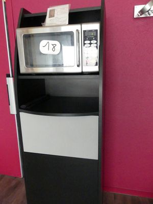 un micro-ondes posé sur une étagère