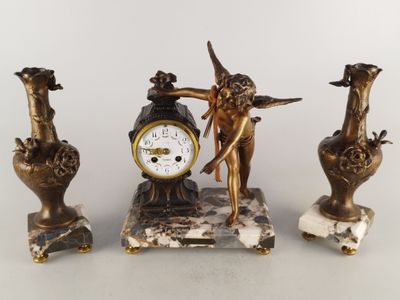 trois statues d'anges et une horloge posée sur une table
