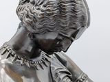 bronze statue of a woman holding a baseball bat on a pedestal