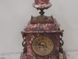 une petite horloge posée sur une table en marbre