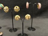 three pairs of earrings and a pair of earrings on a stand
