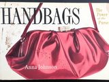 une image représentant un livre sur lequel est posé un sac à main rouge