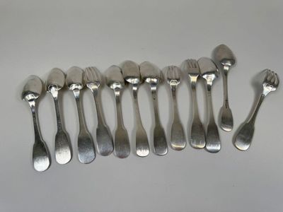 six spoons and a fork are arranged in a row on a table
