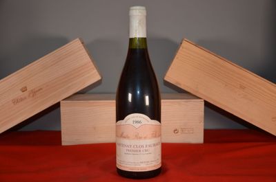 a bottle of wine sitting on a table next to two wooden boxes