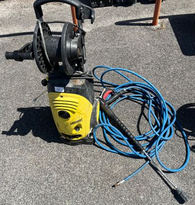 un manomètre jaune posé par terre à côté d'un tuyau bleu