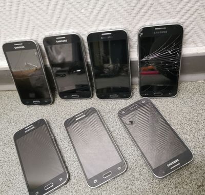 five different samsung phones are lined up next to each other on the floor
