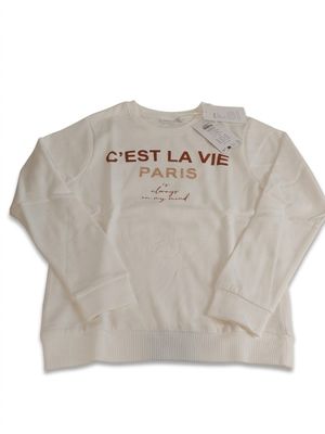 Le pull est blanc et comporte un imprimé doré.