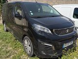 une petite camionnette noire garée à côté d'une camionnette blanche