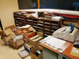 a cluttered office with a lot of boxes on the desk