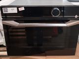 a black oven sitting on a cardboard box in a store