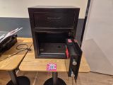 un petit coffre-fort posé sur une table à côté d'une imprimante