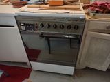 a stove in a kitchen with a lot of clutter on the counter