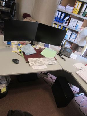 un bureau sur lequel sont posés deux écrans d'ordinateur et un clavier