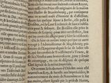 a book open to a page of text on a white surface