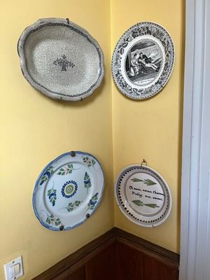 de nombreuses assiettes accrochées au mur, dans un coin de la pièce