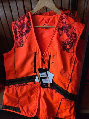 an orange vest with a cell phone attached to it sitting on a chair
