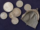 several coins in a mesh bag on a blue surface