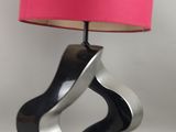une lampe surmontée d'un abat-jour rose