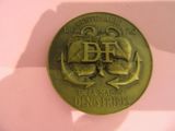 une médaille d'or sur laquelle est représenté un bateau