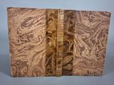 un vieux livre à la couverture brune posé sur une table
