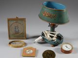 une table sur laquelle se trouvent une lampe, un cadre photo, une horloge, un tableau et une image représentant un squelette
