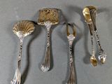 three silver spoons and two silver spoons sitting on a table