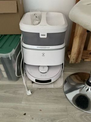 a white and gray water dispenser sitting on the floor next to a chair