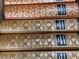 Plusieurs vieux livres sont empilés dans une boîte posée sur une table
