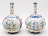 pair of blue and white vases with figures on them on a white surface
