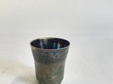 une image représentant une petite tasse posée sur une surface blanche