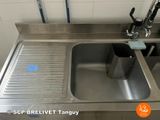 a stainless steel sink in a bathroom with a faucet