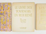 three books are lined up on a wall with a white background