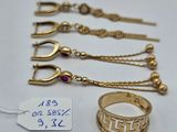 three gold rings and a gold chain with a price tag