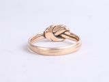 a close up of a gold ring with a knot on it