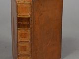 an old book sitting on top of a table next to a gray background