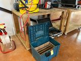 a blue tool box sitting on the floor next to a workbench