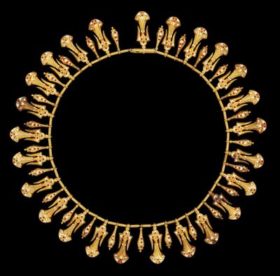 un collier en or orné d'éléphants et de fleurs sur fond noir