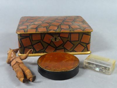 une petite boîte en bois sur laquelle sont posées une poupée et d'autres objets