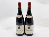 deux bouteilles de vin rouge posées l'une à côté de l'autre sur une surface blanche
