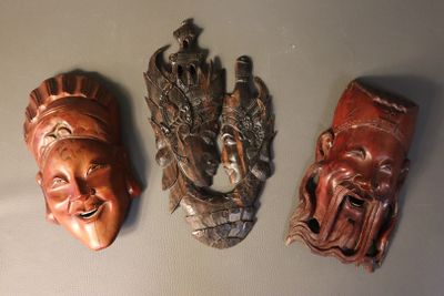 three wooden masks on the wall of a room