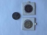 two coins sitting next to each other on a white surface