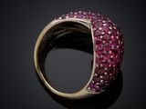 a close up of a ring with pink stones on a black surface