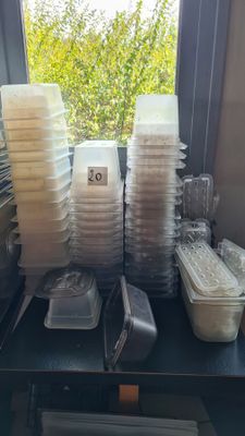 many plastic containers sitting on a table next to a window