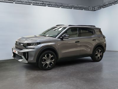 the silver suv is parked in a large room with white walls
