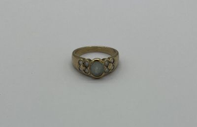 une bague en or avec une pierre verte au centre
