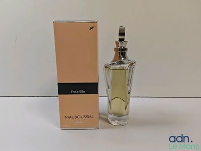 le flacon de parfum se trouve à côté de la boîte, sur la table