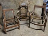 trois chaises en bois assises l'une à côté de l'autre dans une pièce