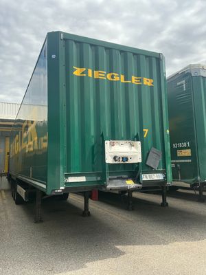 un camion-benne vert garé sur un parking