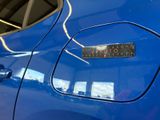 a close up of a blue car with a sticker on it