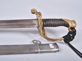 a silver and gold sword with a black cord